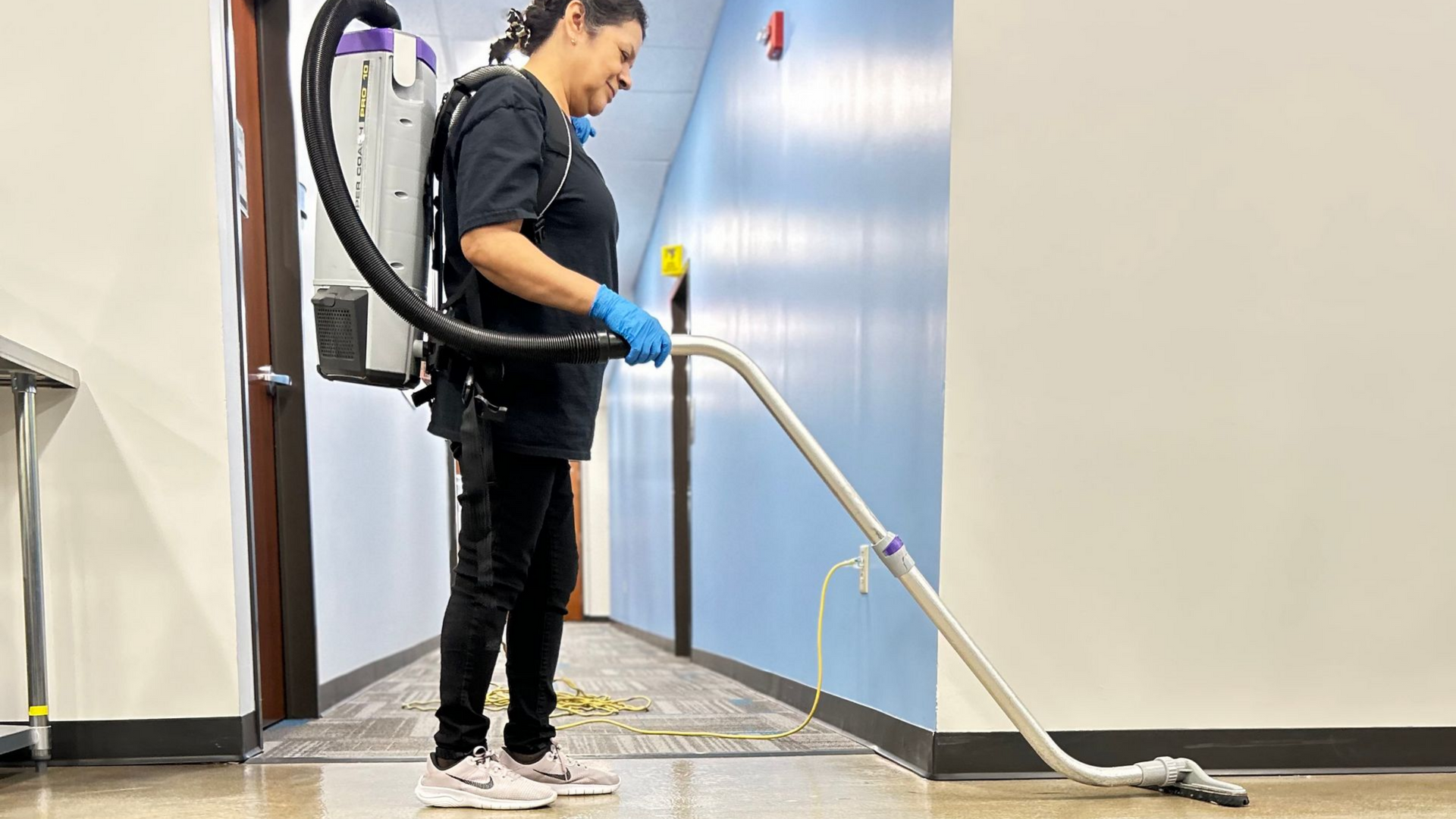 A person using commercial backpack vacuum cleaner A person using commercial backpack vacuum cleaner