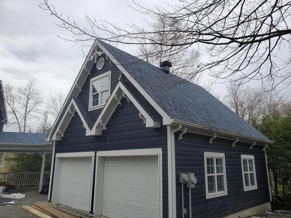 Garage bleu avec des garnitures blanches et deux portes de garage.