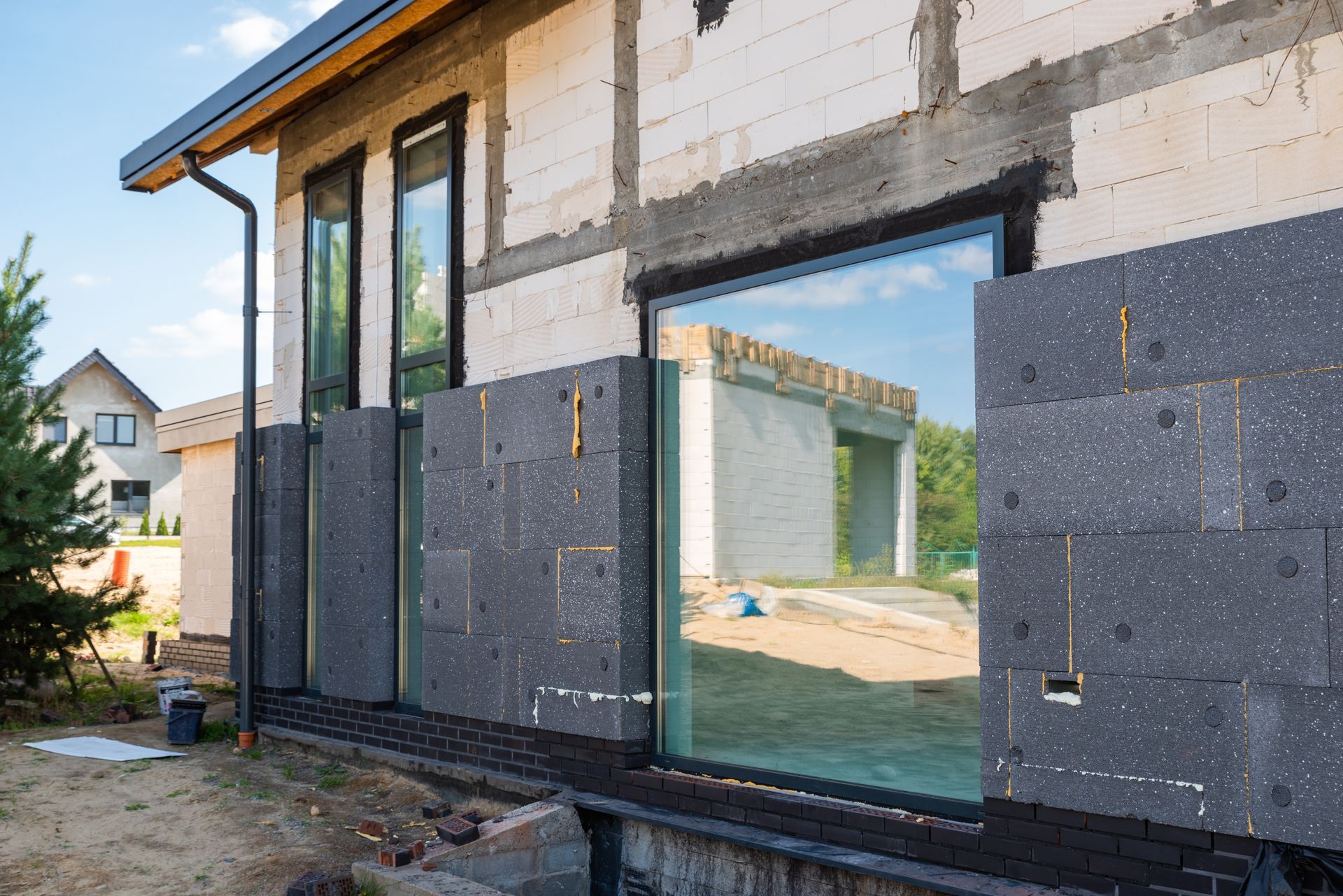 Vue extérieure d'une maison en construction avec panneaux d'isolation installés.