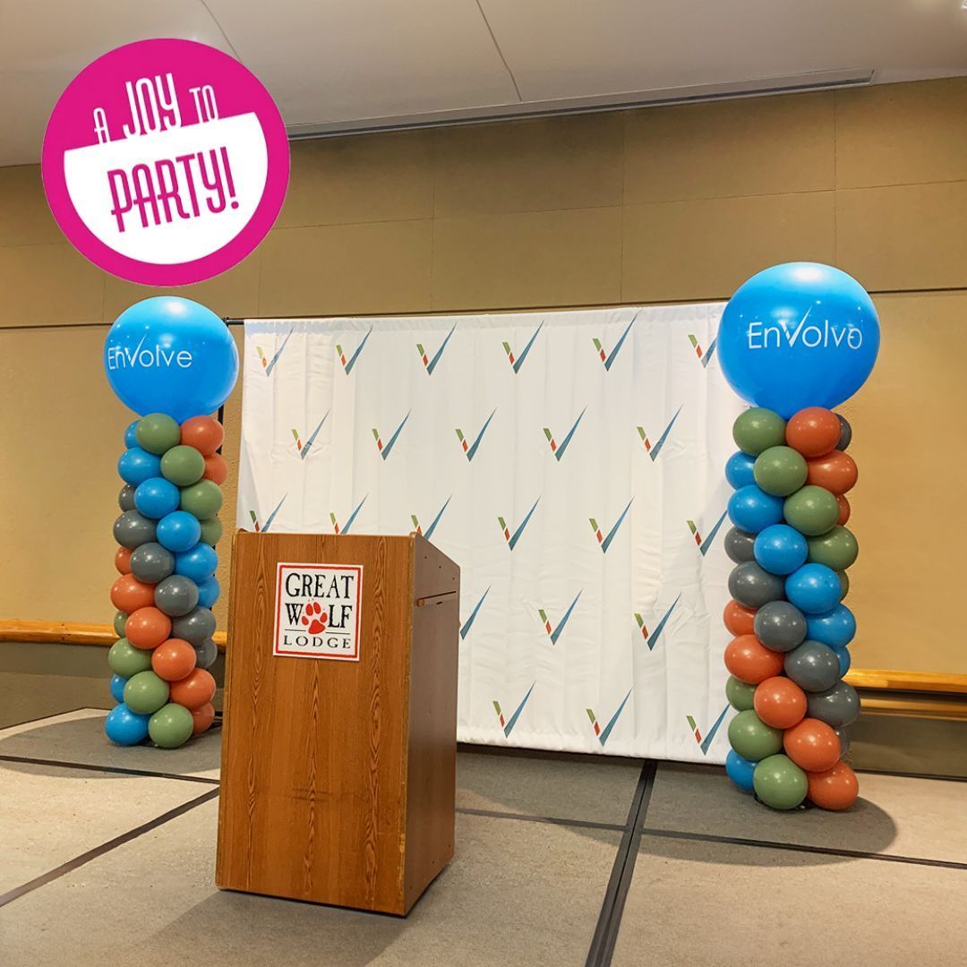 A room decorated with balloons and lights for a party.