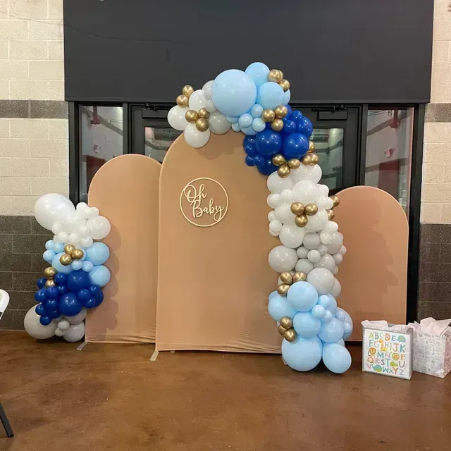 A baby 's first birthday is being celebrated with balloons and lights.