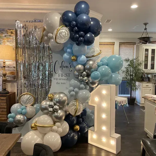 A room decorated with pink and white balloons and the word baby.
