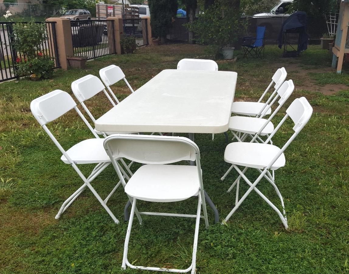A white folding table with black legs on a white background