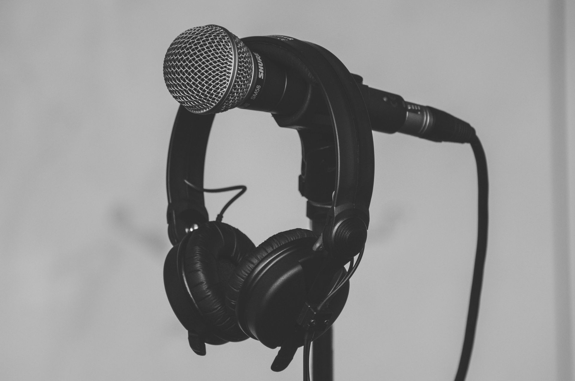 A black and white photo of a microphone and headphones on a stand.