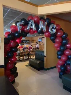 Balloon arch in red, black, and silver spelling 