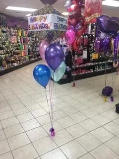 A bunch of balloons are sitting on the floor in a store.