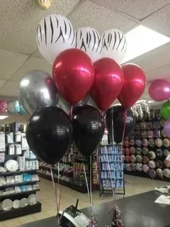 A bunch of balloons are sitting on a table in a store.