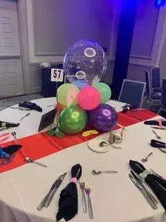 A table set for a party with balloons on it.