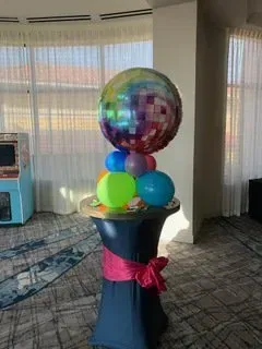 A bunch of balloons are sitting on top of a table in a room.