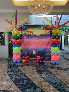 A room filled with colorful balloons and a chandelier.