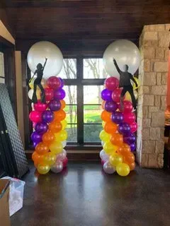 A room filled with balloons and silhouettes of people dancing.