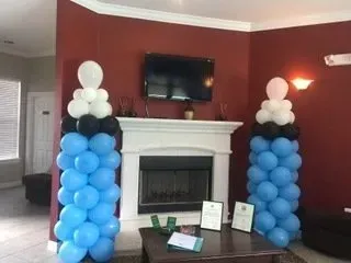 A living room filled with balloons and a fireplace.
