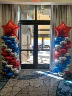 A room filled with red , white and blue balloons.