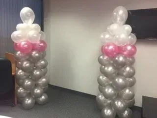 Two columns of balloons are sitting next to each other in a room.