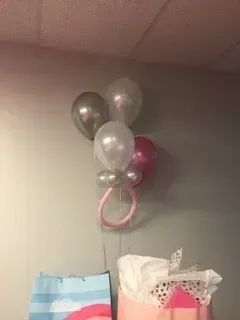 A bunch of balloons are hanging from the ceiling in a room.
