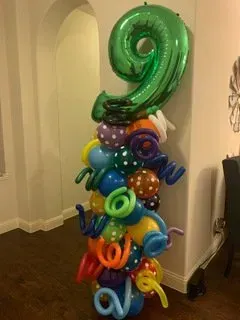 A bunch of balloons are stacked on top of each other in a room.