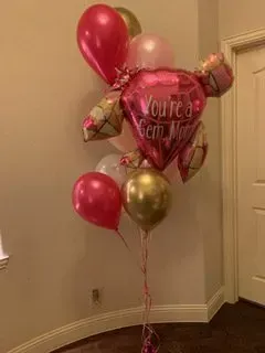 A bunch of balloons are sitting on the floor in a room.
