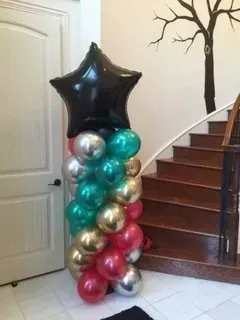 A bunch of balloons are stacked on top of each other in front of a staircase.