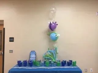 A table with balloons and cups on it in a room.