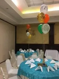 A room with tables and chairs and balloons hanging from the ceiling.