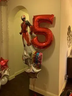 A bunch of balloons are sitting on top of each other on a wall.