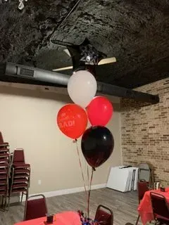 A bunch of balloons are sitting on top of a table in a room.