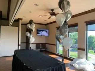 A room with a table and balloons in it.