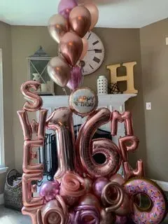 A bunch of balloons are sitting on top of each other in a living room.