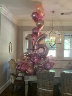 A bunch of balloons are sitting on top of a table in a room.