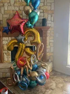 A bunch of balloons are sitting on the floor in a living room.