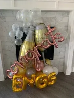 A bunch of balloons are sitting on top of a fireplace.
