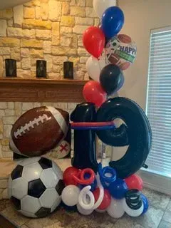 A bunch of balloons are stacked on top of each other in a room.
