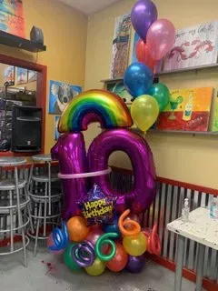 A room filled with balloons and a purple number 10 balloon.