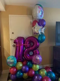A bunch of balloons are stacked on top of each other in a room.