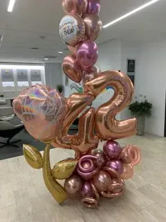 A bunch of balloons are sitting on a table in a room.