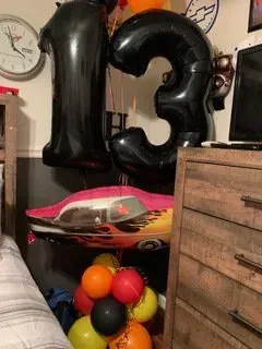 A bedroom with a bunch of balloons in the shape of the number 13.