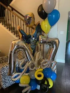 A bunch of balloons are sitting on the floor in front of a staircase.