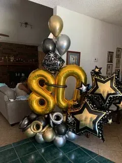 A bunch of balloons are sitting in a living room.