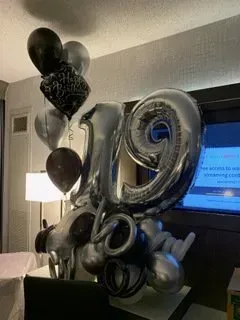 A bunch of balloons are sitting on a table in a room.