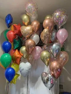 A bunch of balloons are hanging from the ceiling in a room.