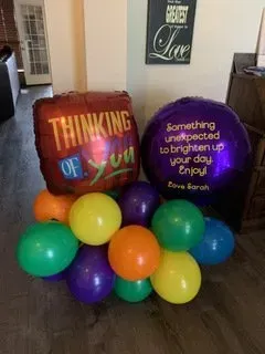 A bunch of balloons with one that says `` something unexpected to brighten up your day enjoy ''
