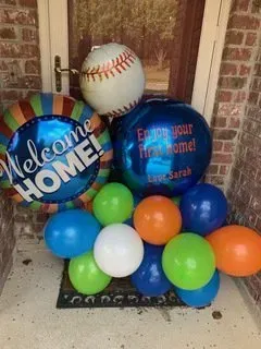 A bunch of balloons are sitting on a door mat.