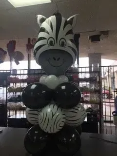 A zebra made out of balloons is sitting on a table.