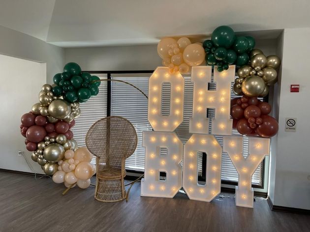 A room with balloons and a sign that says oh boy