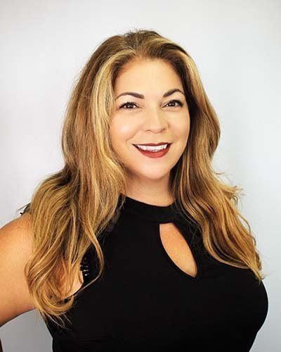 a woman with long blonde hair is wearing a black tank top and smiling .