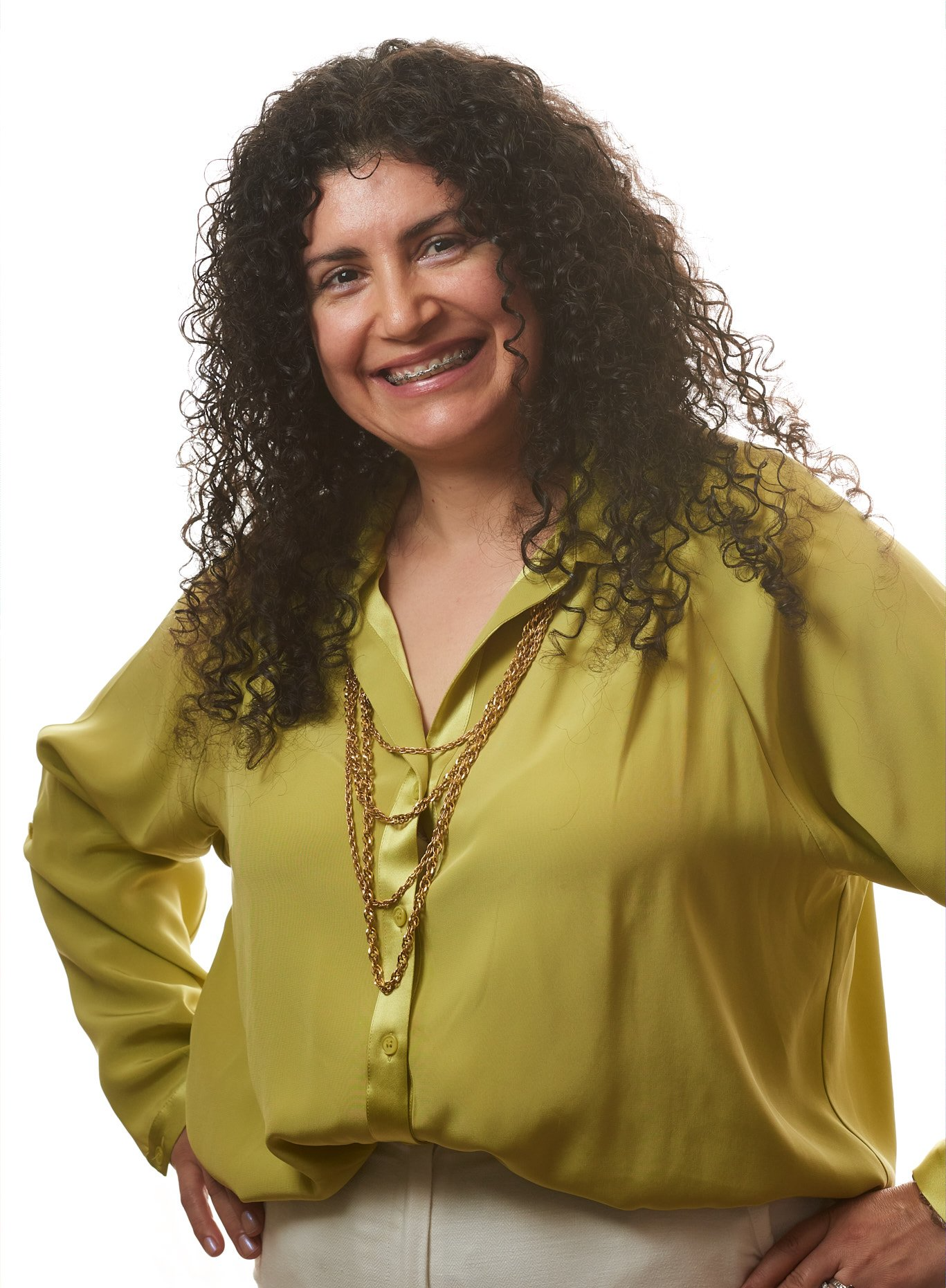 A woman with curly hair is wearing a yellow shirt