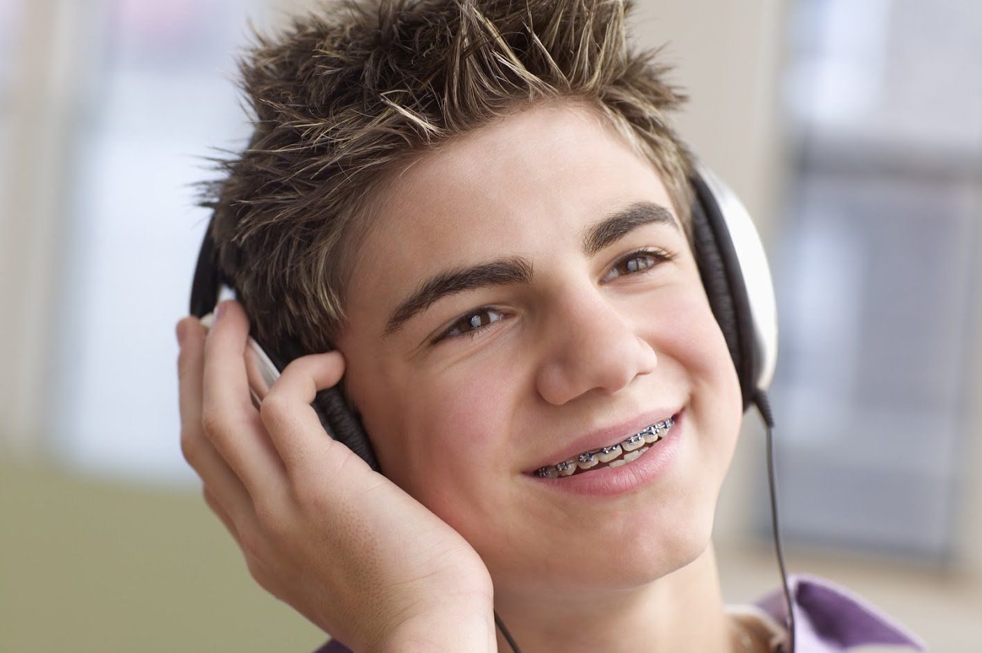 Boy wearing braces listening to music — Buffalo Grove, IL — Rosen Orthodontics Boy wearing braces listening to music — Buffalo Grove, IL — Rosen Orthodontics