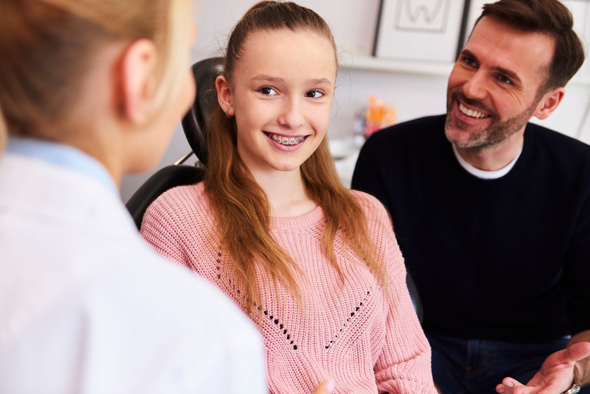 Happy girl and her dad during a dental appointment.