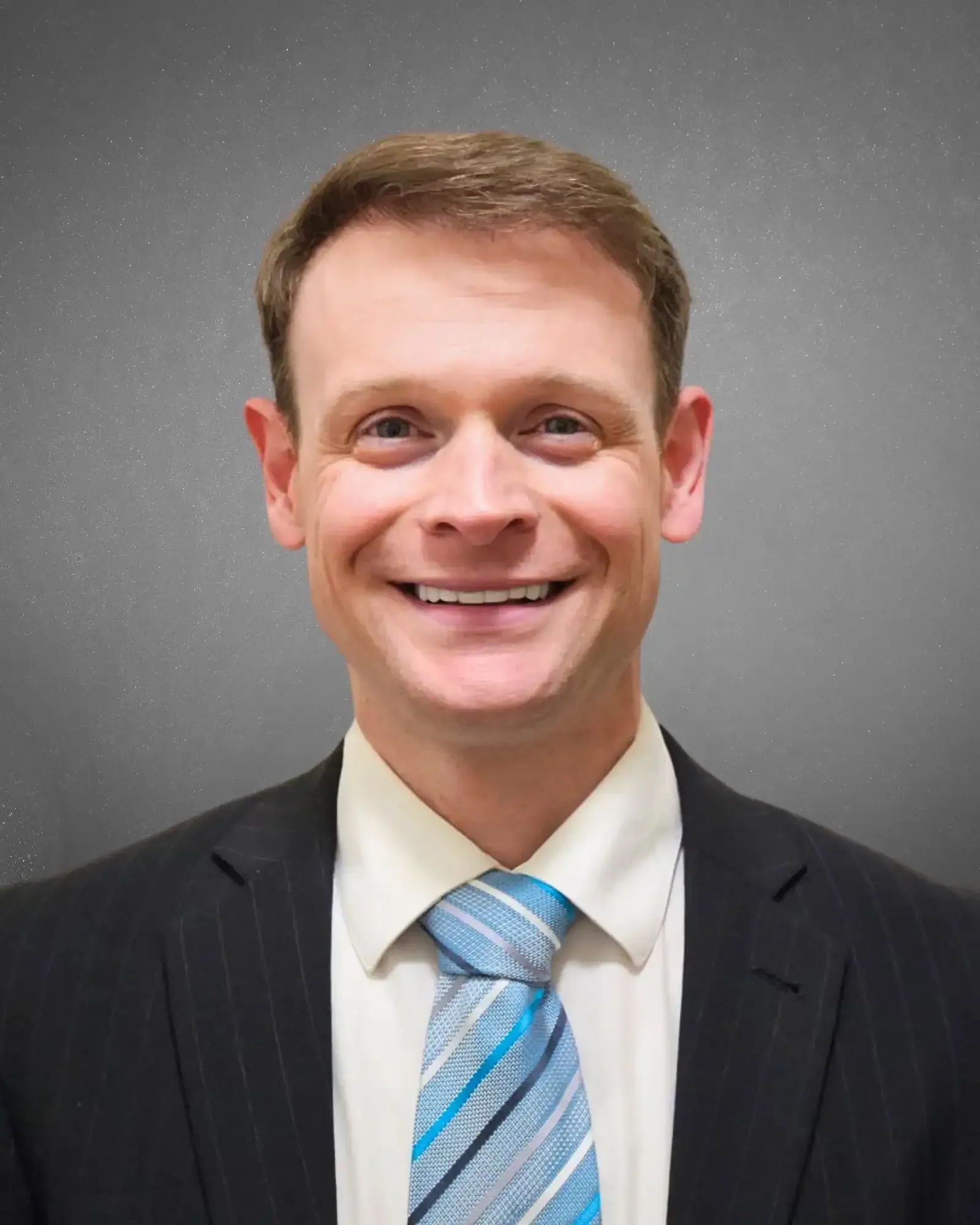 Teacher Tim in a suit and tie is smiling for the camera.