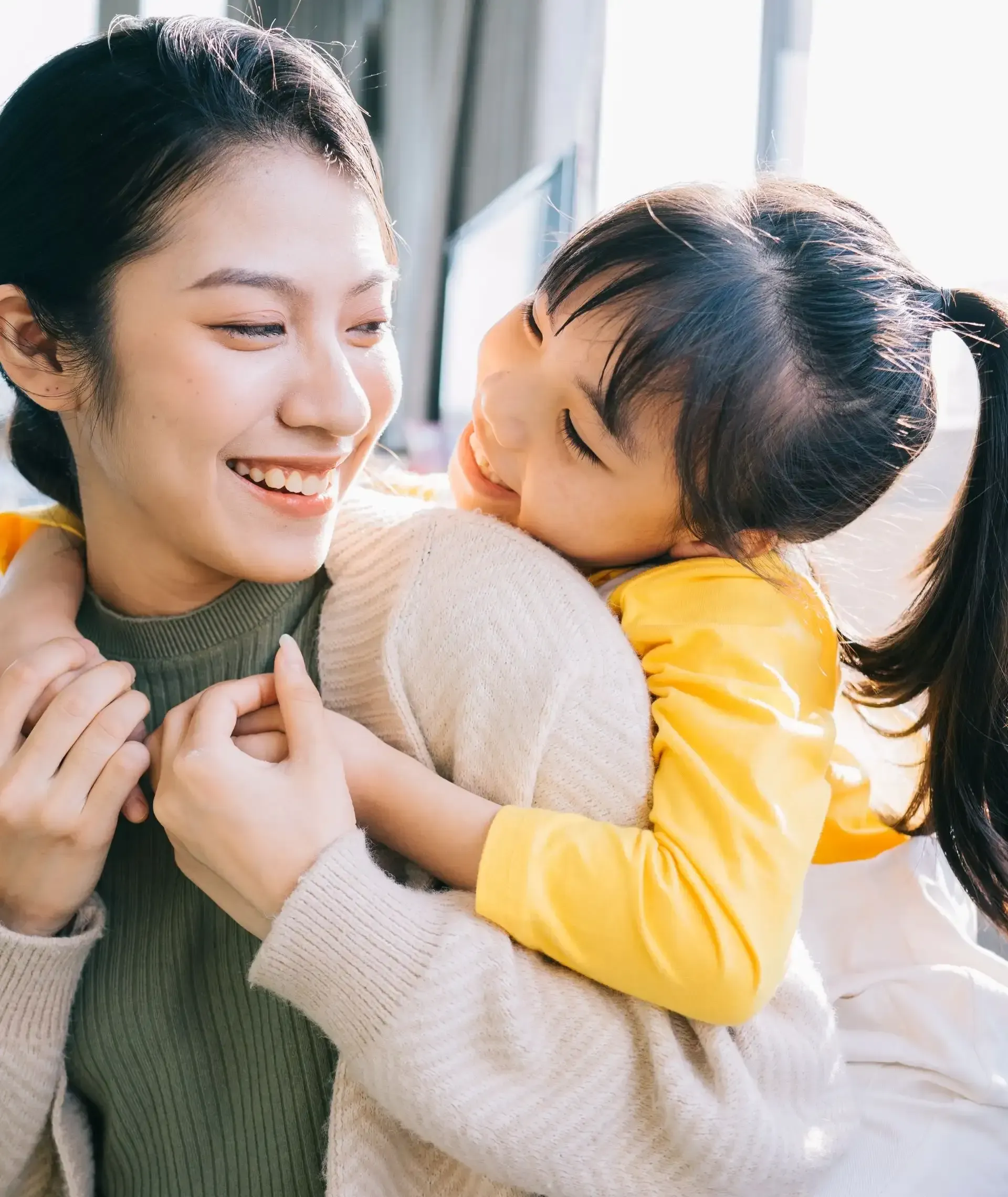 A woman is holding a little girl in her arms.